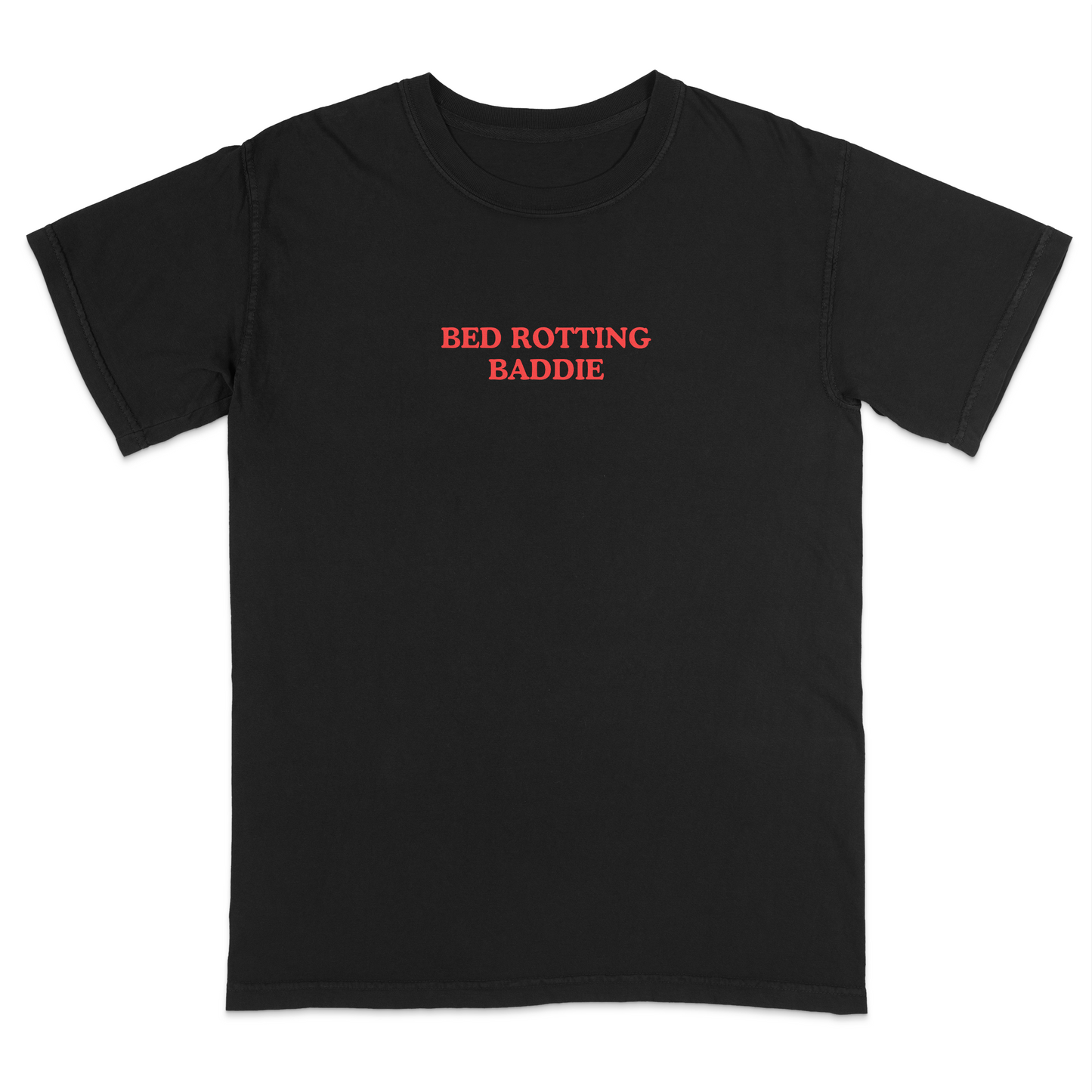 Front view of a black graphic T-shirt featuring the phrase "BED ROTTING BADDIE" in small vintage-style red lettering centered on the chest. This minimalist, trendy tee combines clean aesthetics with humorous Gen Z-inspired text for a casual everyday look.