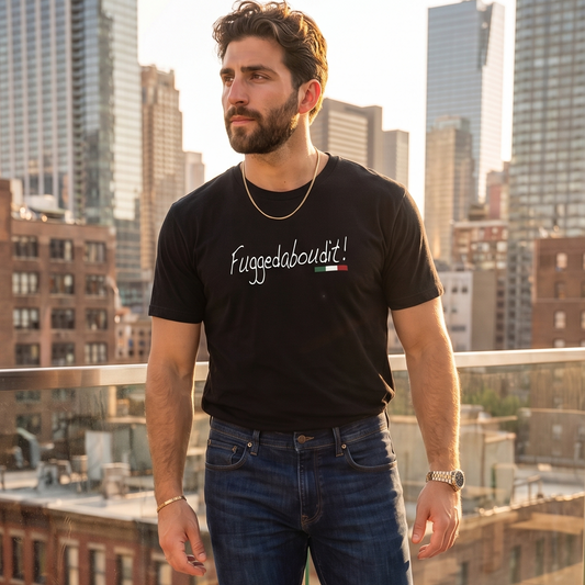 Man wearing a black “Fuggedaboutit!” graphic t-shirt with Italian flag accent, standing on a rooftop overlooking a city skyline. Stylish Italian heritage shirt featuring a classic Italian expression, perfect for Italian pride, family gatherings, and casual everyday wear.