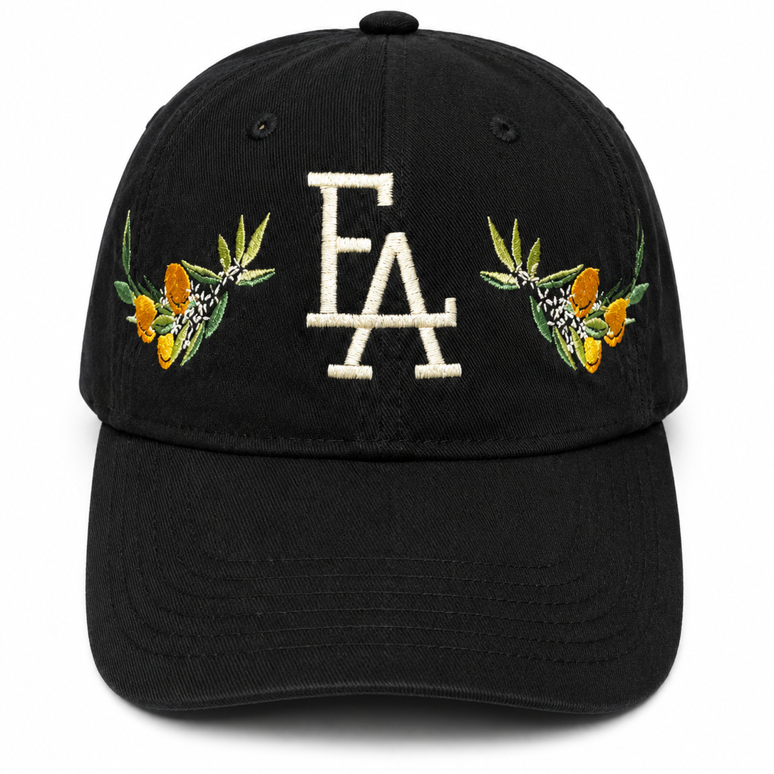 Black baseball cap featuring a white embroidered “FLA” logo on the front, accented with colorful citrus and floral embroidery on both sides for a Florida-inspired design.