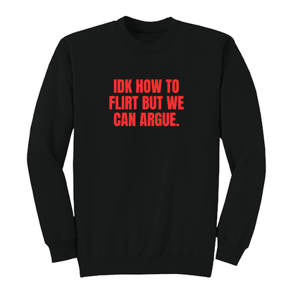 Front view of a black long sleeve graphic crewneck featuring the bold red statement "IDK HOW TO FLIRT BUT WE CAN ARGUE." centered across the chest in large uppercase block lettering. This funny sarcastic long sleeve shirt combines relationship humor with bold typography, making it a casual streetwear piece for adults with a playful sense of humor.