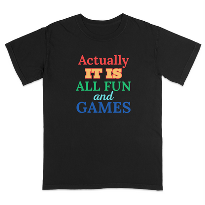 Front view of a black graphic T-shirt featuring the phrase "Actually It Is All Fun and Games" in bold multicolored lettering, with "Actually" in red, "IT IS" in gold, "ALL FUN" in green, "and" in light blue script, and "GAMES" in blue. This colorful humorous graphic tee has a playful retro-inspired design, making it perfect for casual wear, parties, game nights, and everyday outfits.