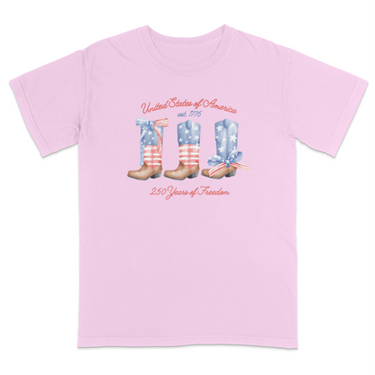 Blossom patriotic graphic tee featuring vintage American flag cowboy boots with “United States of America,” “Est. 1776,” and “250 Years of Freedom” text for a western-inspired Americana look.
