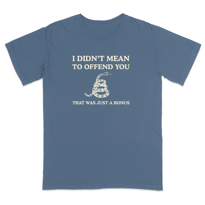 Front view of a blue jean graphic T-shirt featuring the humorous phrase "I DIDN'T MEAN TO OFFEND YOU" above a coiled rattlesnake illustration and the text "THAT WAS JUST A BONUS." This vintage-inspired graphic tee combines bold typography with Western-style artwork for a funny, sarcastic everyday shirt.