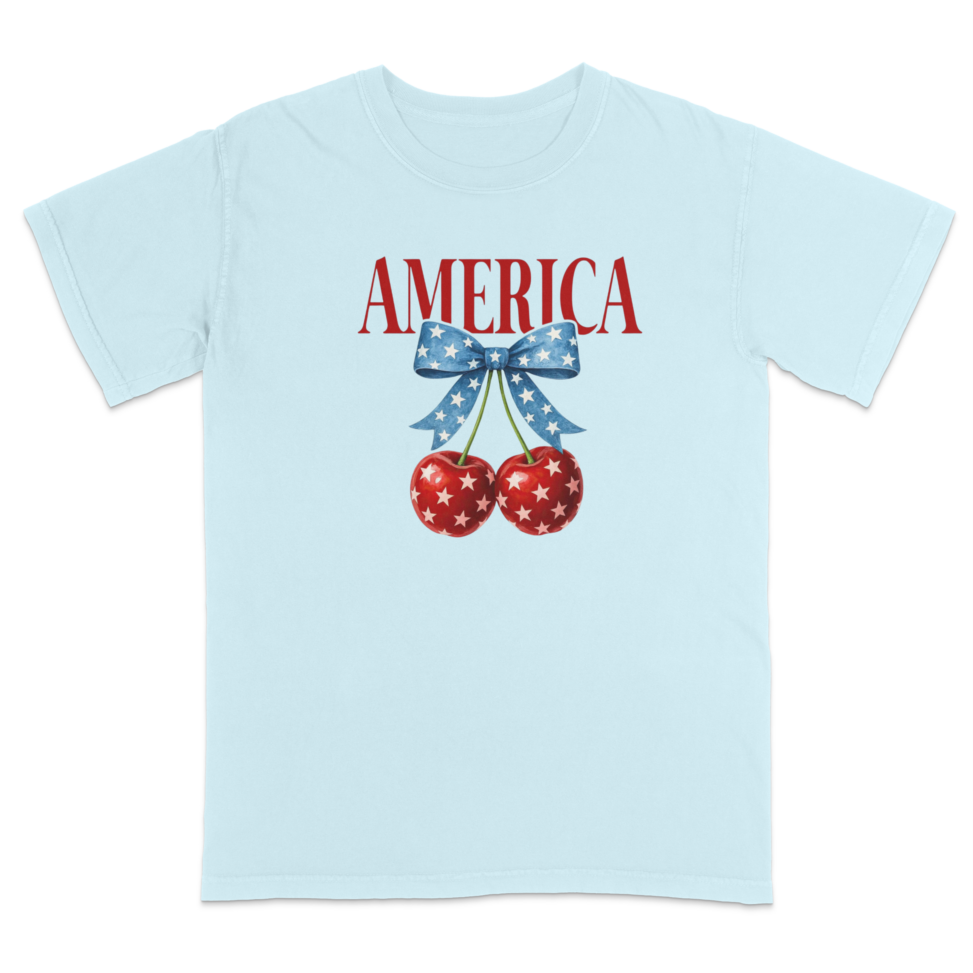 Light Blue patriotic graphic t-shirt featuring red “AMERICA” text with star-pattern cherries and a blue bow design, combining vintage Americana style with playful patriotic fashion.