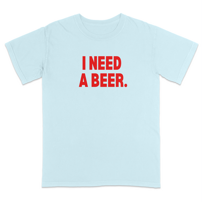 Light Blue graphic t-shirt featuring bold red “I NEED A BEER.” text on the front, minimalist typography design, and casual humor-inspired streetwear style.