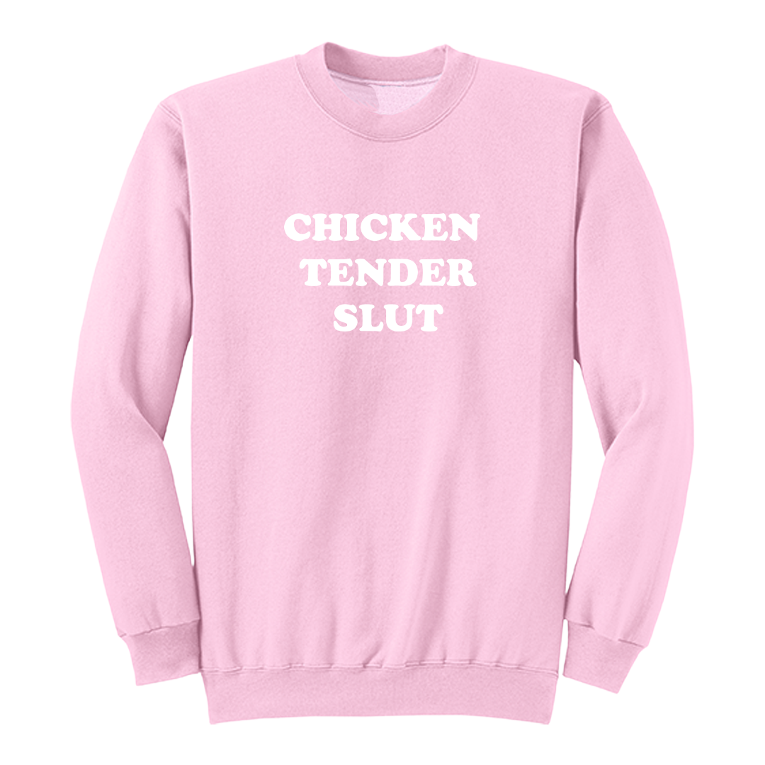 Front view of a light pink crewneck sweatshirt featuring the bold white stacked phrase "CHICKEN TENDER SLUT" in large retro bubble lettering centered on the chest. The simple vintage-inspired typography stands out against the black fabric, creating a humorous foodie-themed graphic sweatshirt with a clean, minimalist, and playful design.