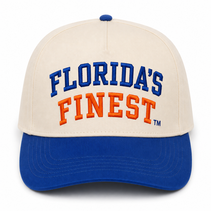 Cream and royal blue two-tone snapback hat featuring embroidered “Florida’s Finest™” text in bold collegiate lettering across the front. The cream crown is paired with a royal blue curved brim, with “Florida’s” stitched in royal blue and “Finest” embroidered in vibrant orange. Stylish Florida-inspired headwear perfect for game days, beach trips, tailgates, outdoor adventures, and everyday Florida pride.