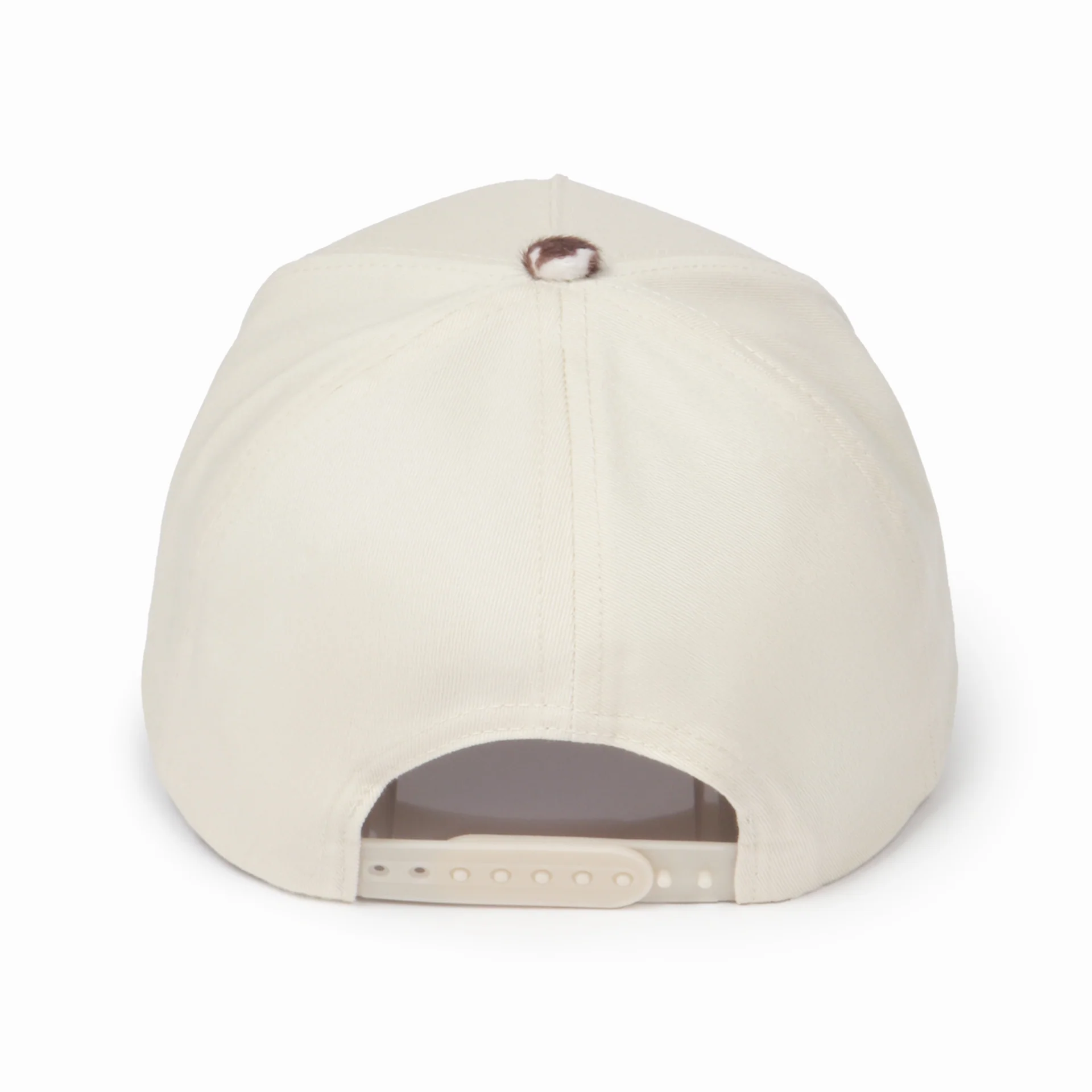 Back view of a cream snapback hat featuring a brown and cream cow print top button and an adjustable cream snapback closure. Displayed on a white background, showcasing the clean rear design and structured fit.