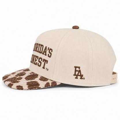 Side view of a cream snapback hat featuring brown embroidered "Florida's Finest" text, a brown FLA® logo on the side panel, and a brown and cream cow print curved bill. Displayed on a white background with an adjustable snapback closure visible.