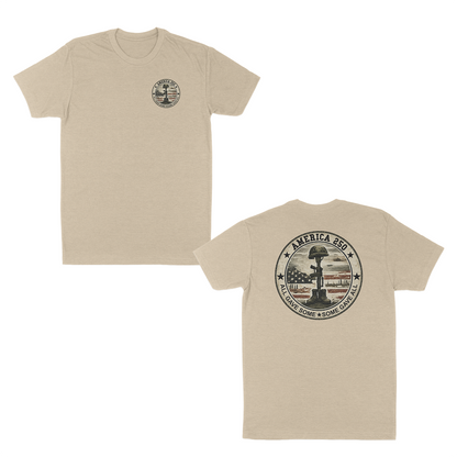 Cream patriotic memorial t-shirt featuring a small front chest badge and large back graphic with battlefield cross memorial, distressed American flag, “America 250” design, and “All Gave Some • Some Gave All” tribute text.