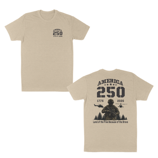 Cream patriotic military t-shirt featuring a small “America 250” chest print and oversized back graphic with armed soldier, helicopters, “1776–2026” anniversary text, and “Land of the Free Because of the Brave” design.
