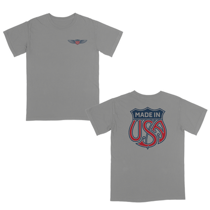 Grey patriotic graphic t-shirt with small USA wing logo on the front and oversized “Made in USA” graphic on the back in vintage red and blue Americana style.