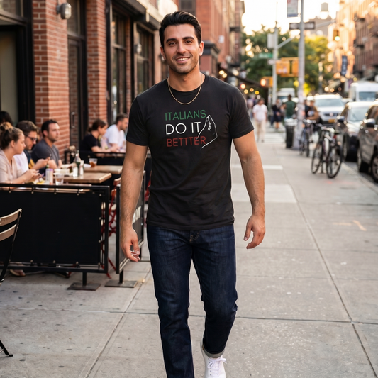 Man wearing a black “Italians Do It Better” graphic t-shirt featuring Italian flag colors while walking through a city street. Stylish Italian heritage shirt celebrating Italian pride, culture, family traditions, and casual everyday fashion.