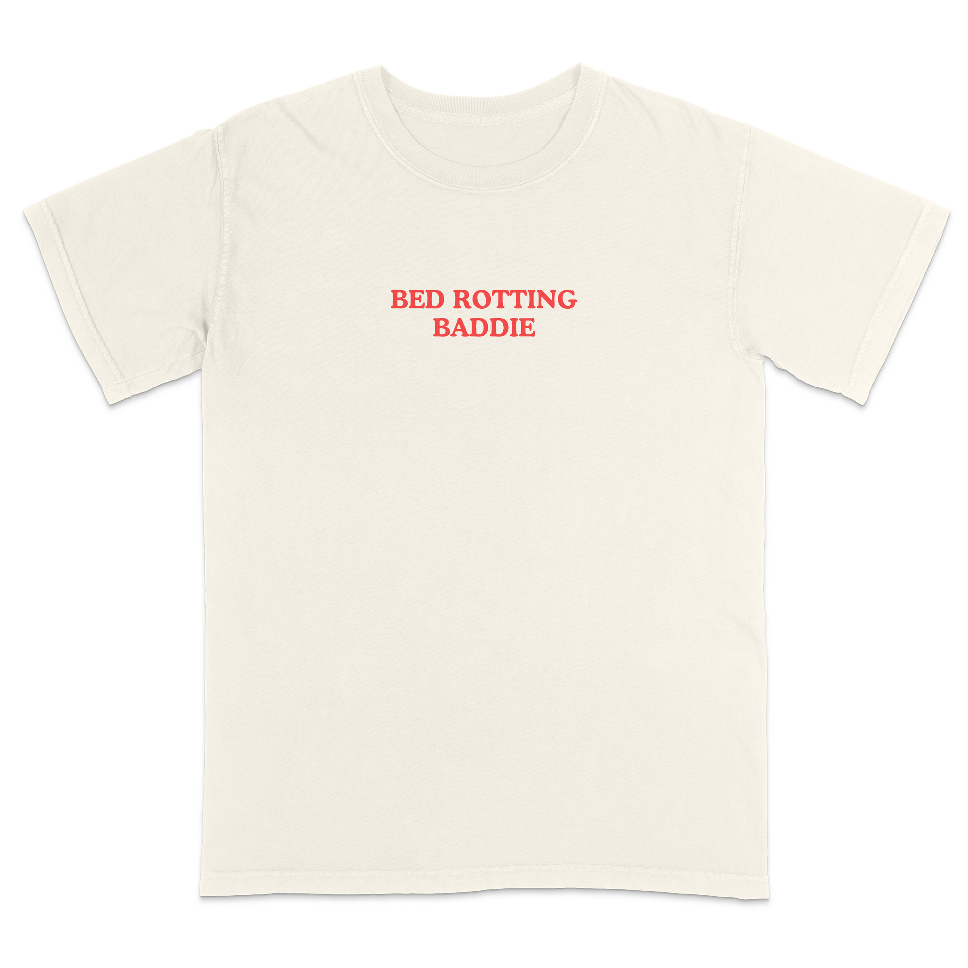 Front view of a ivory graphic T-shirt featuring the phrase "BED ROTTING BADDIE" in small vintage-style red lettering centered on the chest. This minimalist, trendy tee combines clean aesthetics with humorous Gen Z-inspired text for a casual everyday look.