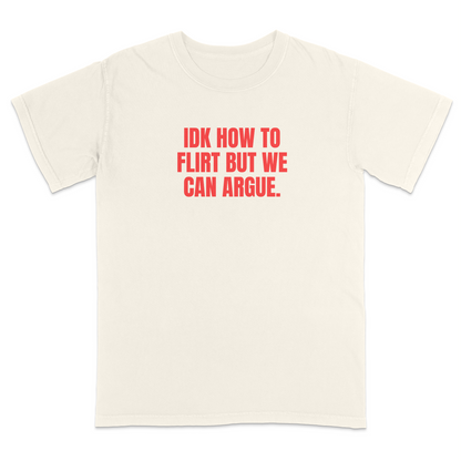 Front view of a ivory graphic T-shirt featuring the bold red statement "IDK HOW TO FLIRT BUT WE CAN ARGUE." centered across the chest in large uppercase block lettering. This funny sarcastic T-shirt combines relationship humor with bold typography, making it a casual streetwear design for adults with a playful sense of humor.