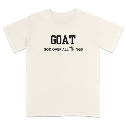 Ivory faith-based Christian t-shirt featuring the bold word “GOAT” across the chest with the phrase “God Over All Things” underneath and a white cross graphic. Inspirational religious apparel designed for believers, church events, youth groups, Christian streetwear, Bible study gatherings, and everyday faith-centered fashion.
