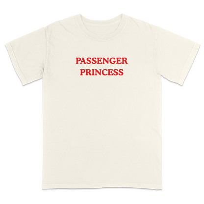 Front view of a ivory graphic T-shirt featuring the phrase "PASSENGER PRINCESS" in bold red vintage-style lettering centered across the chest. This minimalist graphic tee offers a playful automotive-inspired design, making it perfect for road trips, date nights, vacations, casual outings, and everyday wear.