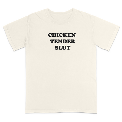 Front view of a ivory graphic t-shirt featuring the bold black stacked phrase "CHICKEN TENDER SLUT" in large retro bubble lettering across the upper chest. The minimalist design uses clean vintage-inspired typography with strong contrast against the black fabric, creating a humorous foodie-themed statement tee with a playful, sarcastic aesthetic.