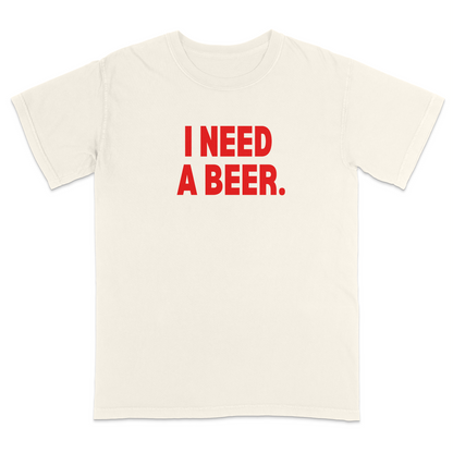 Ivory graphic t-shirt featuring bold red “I NEED A BEER.” text on the front, minimalist typography design, and casual humor-inspired streetwear style.