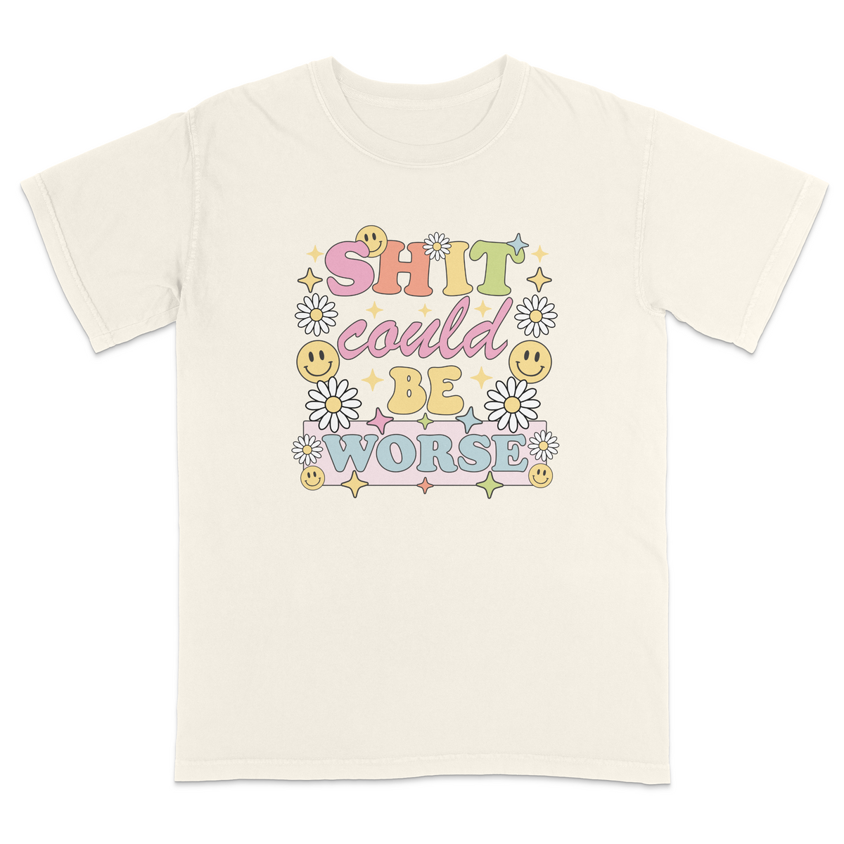 Front view of a ivory graphic t-shirt featuring a retro-inspired pastel design with the phrase "SHIT could BE WORSE" in colorful vintage lettering. The design is decorated with white daisies, yellow smiley faces, and sparkling star accents, creating a playful 70s aesthetic that contrasts with the humorous sarcastic message. A funny adult graphic tee with retro floral artwork, pastel colors, and bold statement typography for casual everyday wear.