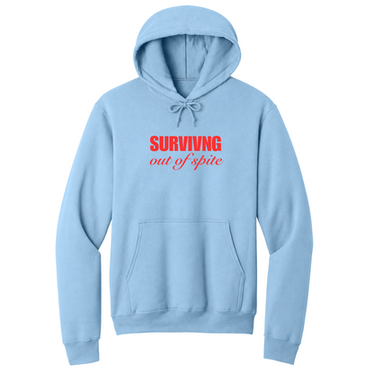 Front view of a light blue pullover hoodie featuring the phrase "SURVIVING" in bold red block letters above the words "out of spite" in elegant red script centered on the chest. The minimalist motivational graphic contrasts sharply against the black fabric, creating a clean, modern hoodie with a witty and resilient statement design.