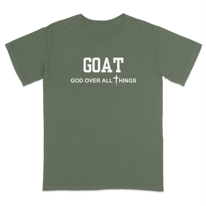 Moss faith-based Christian t-shirt featuring the bold word “GOAT” across the chest with the phrase “God Over All Things” underneath and a white cross graphic. Inspirational religious apparel designed for believers, church events, youth groups, Christian streetwear, Bible study gatherings, and everyday faith-centered fashion.