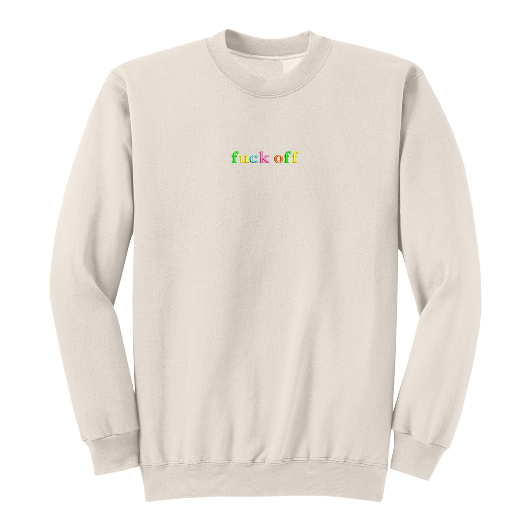 Front view of a natural long sleeve crewneck featuring the phrase "fuck off" in small lowercase letters centered across the chest. Each letter is embroidered in a different bright color, creating a subtle rainbow-inspired design with a clean, minimalist aesthetic. A bold adult long sleeve shirt with colorful typography, casual streetwear style, and sarcastic humor.