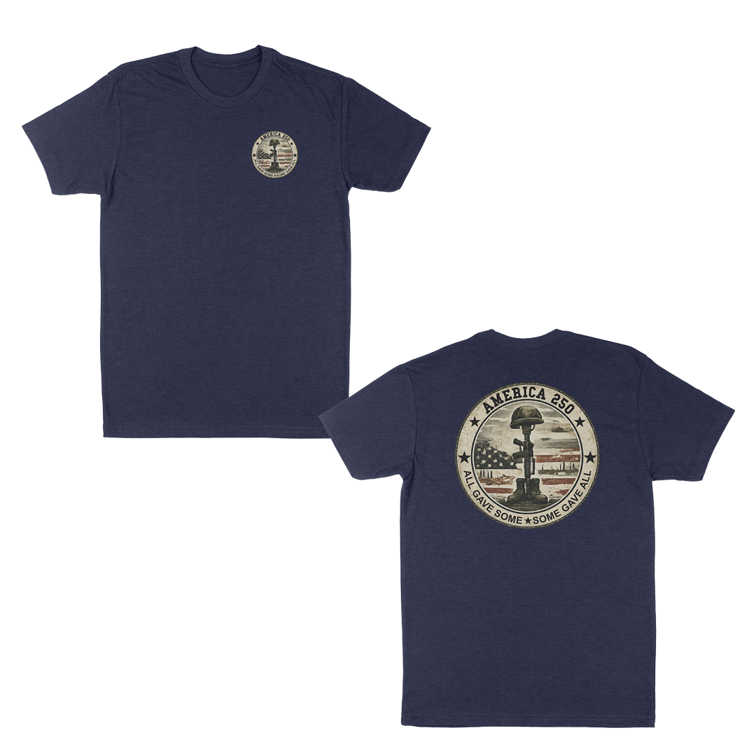 Navy patriotic memorial t-shirt featuring a small front chest badge and large back graphic with battlefield cross memorial, distressed American flag, “America 250” design, and “All Gave Some • Some Gave All” tribute text.
