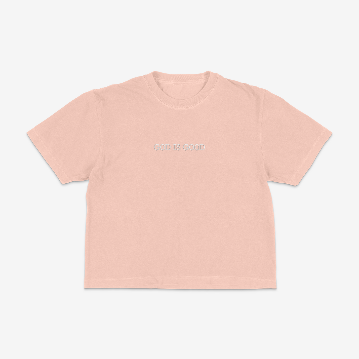 Peach boxy tee with 'GOD IS GOOD' text on a white background