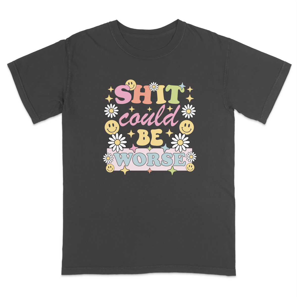 Front view of a pepper graphic t-shirt featuring a retro-inspired pastel design with the phrase "SHIT could BE WORSE" in colorful vintage lettering. The design is decorated with white daisies, yellow smiley faces, and sparkling star accents, creating a playful 70s aesthetic that contrasts with the humorous sarcastic message. A funny adult graphic tee with retro floral artwork, pastel colors, and bold statement typography for casual everyday wear.