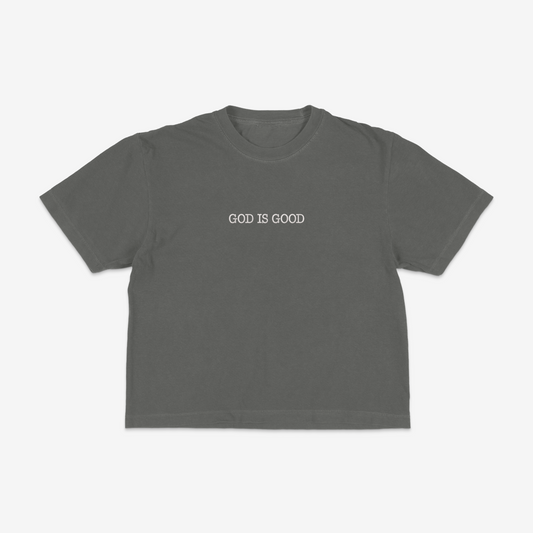 Dark grey boxy tee with 'GOD IS GOOD' text on a white background
