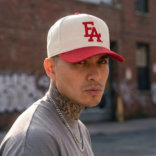 Close-up lifestyle photo of a man wearing a cream and red FLA® snapback hat featuring bold red embroidered lettering. Florida-inspired streetwear cap with a classic two-tone design, perfect for casual fashion, outdoor wear, and everyday style.