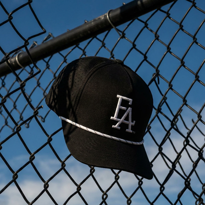 Black FLA® rope hat with white embroidered logo and contrast rope detail, displayed against a chain-link fence. Modern Florida-inspired snapback cap featuring a clean athletic design, perfect for streetwear, outdoor adventures, and everyday casual style.