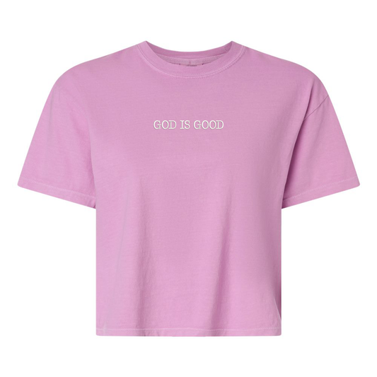 Pink boxy tee with 'GOD IS GOOD' text on a white background