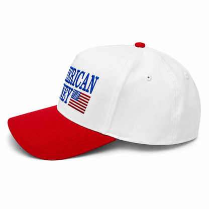 Side view of American Honey patriotic trucker hat featuring blue embroidered lettering, embroidered American flag graphic, white crown, red curved bill, and classic red-white-blue Americana style.
