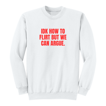 Front view of a white long sleeve graphic crewneck featuring the bold red statement "IDK HOW TO FLIRT BUT WE CAN ARGUE." centered across the chest in large uppercase block lettering. This funny sarcastic long sleeve shirt combines relationship humor with bold typography, making it a casual streetwear piece for adults with a playful sense of humor.