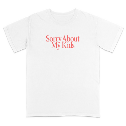 Front view of a white graphic T-shirt featuring the phrase "Sorry About My Kids" in large soft pink serif lettering centered across the chest. This minimalist parenting humor tee offers a clean modern design, making it perfect for moms, dads, school events, family outings, playdates, and everyday casual wear.