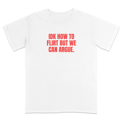 Front view of a white graphic T-shirt featuring the bold red statement "IDK HOW TO FLIRT BUT WE CAN ARGUE." centered across the chest in large uppercase block lettering. This funny sarcastic T-shirt combines relationship humor with bold typography, making it a casual streetwear design for adults with a playful sense of humor.