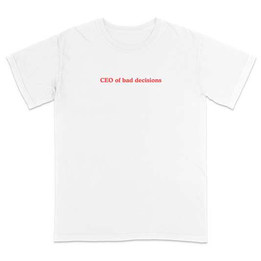 Front view of a white graphic T-shirt featuring the phrase "CEO of bad decisions" in small vintage-style red lettering centered on the chest. This minimalist humor tee offers a clean, trendy design that's perfect for casual everyday wear and sarcastic self-expression.